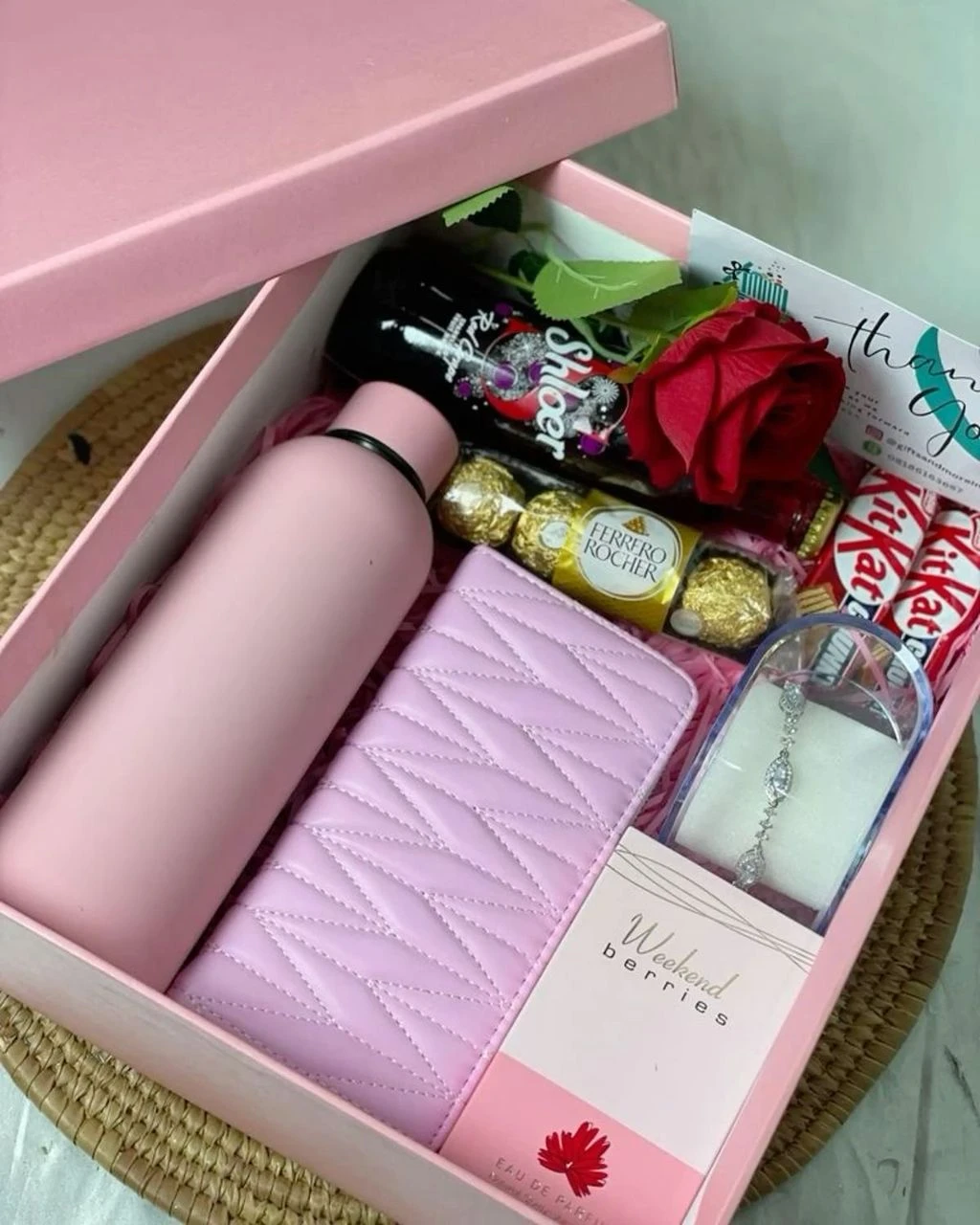 A retainable water flask + wine + perfume + purse + rose + mini box of chocolate + chocolate extras + a  boxed wrist chain PACKAGE